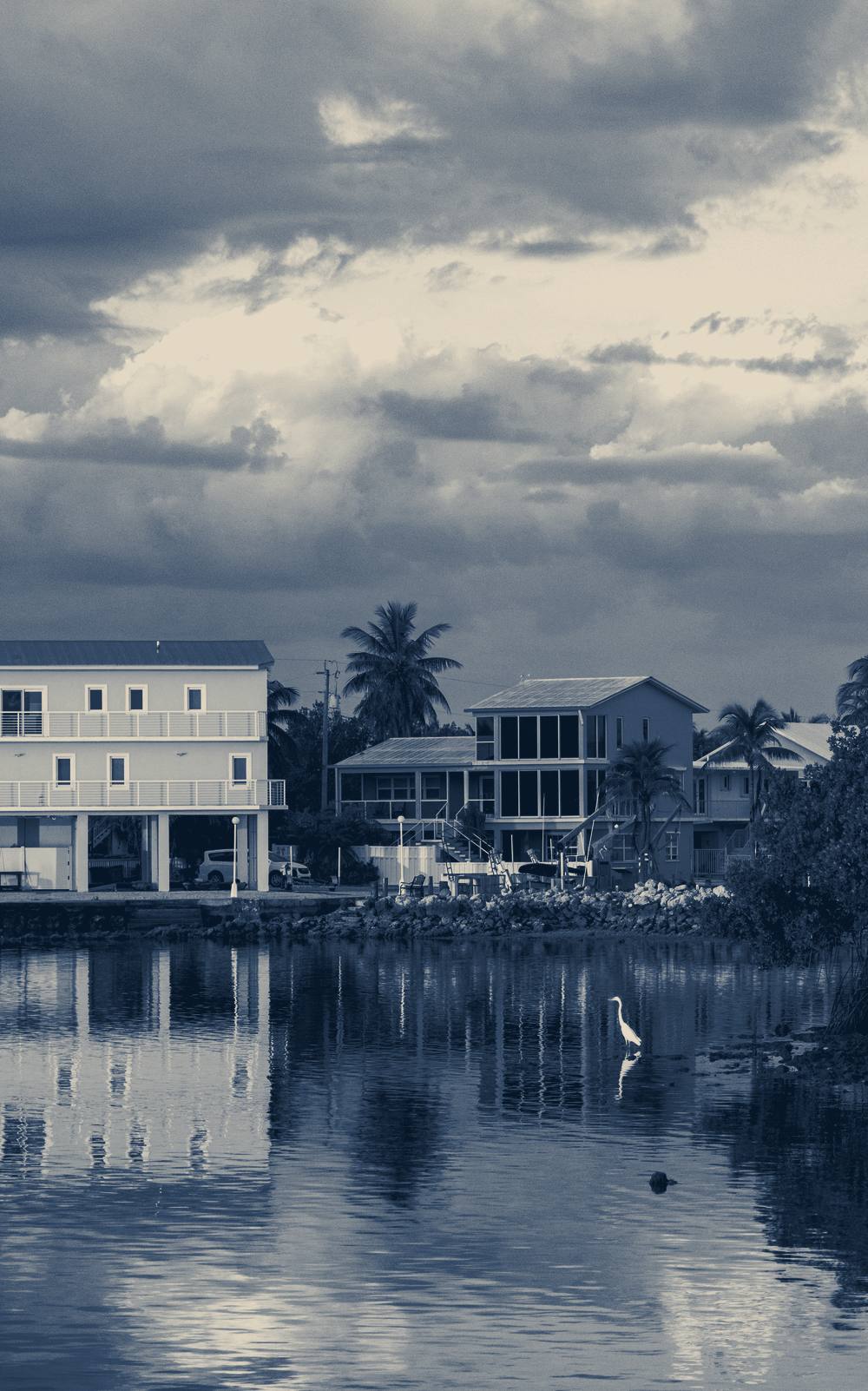 Coastal houses reflected in calm water, Key West, Florida
